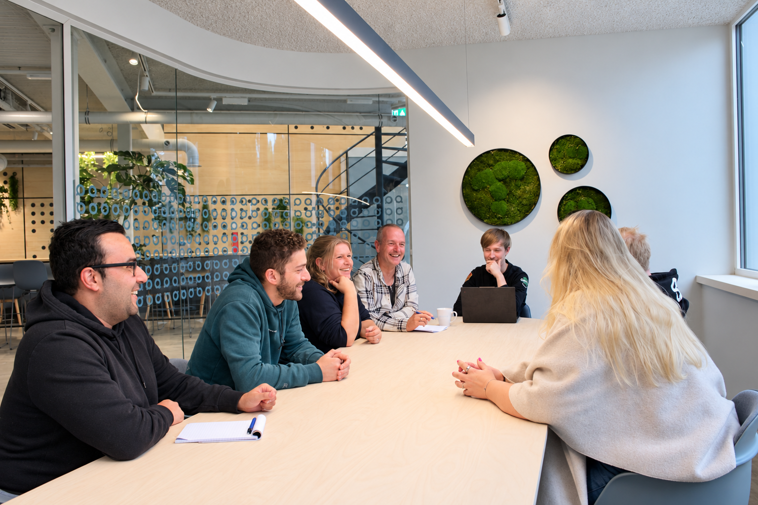 Collega's van Qoden in overleg aan tafel op kantoor in Goor